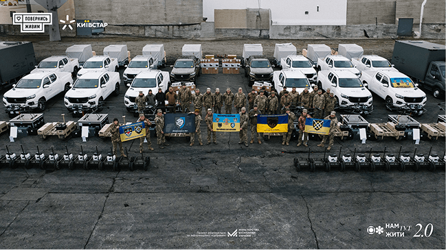 Групове фото військових на тлі автомобілів, дронів та технічного обладнання, переданого для потреб армії